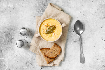 Wall Mural - The cream of chicken soup. Puree soup chicken, carrot and onion soup with cream. Chicken soup in a bowl on the light gray kitchen table. Top view