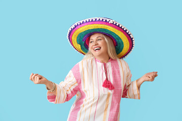 Wall Mural - Mature Mexican woman in sombrero hat on color background