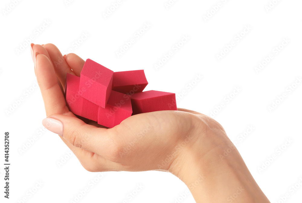 Hand with makeup sponges on white background