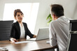 © bnenin - Business meeting. Two business people sitting at office desk discussing work.