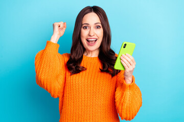 Portrait of astonished pretty lady fist up open mouth celebrate new comment follow isolated on blue color background