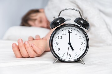 Wall Mural - Sleeping woman on pillow with alarm clock before waking up