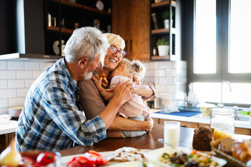 Wall Mural - happy grandparents with grandchildren making breakfast in kitchen