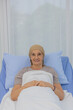 © Bangkok Click Studio - A middle-aged breast cancer patient lay on the bed and looking to camera with strong feeling eyes