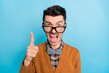 Poster - Photo of unsatisfied handsome guy open mouth yell loud point finger isolated on blue color background