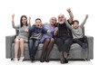 © ASDF - happy family sitting on a large comfortable sofa.