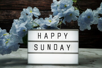Wall Mural - happy sunday word in light box with flowers decoration