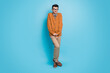 Full size photo of shy modest young nerd guy make timid pose hold hands together isolated on blue color background