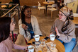 © Zoran Zeremski - Three young multi ethnic women enjoy coffee at a coffee shop