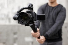 Filmmaking, Hobby And Creativity Concept - Close Up Of Modern Dslr Camera On 3-axis Gimbal In Male Hands