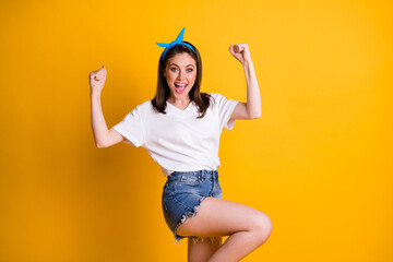 Wall Mural - Portrait of lovely cheerful girl dancing rejoicing great luck win isolated over bright yellow color background