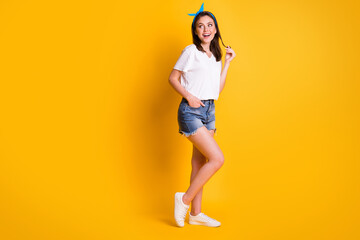 Poster - Full length photo of girl play curl look empty space wear blue headband white t-shirt mini shorts footwear isolated yellow color background