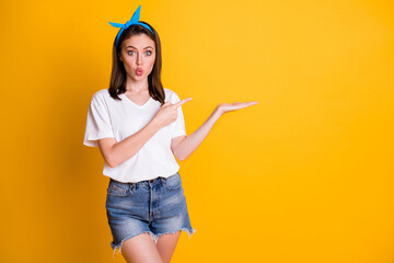 Poster - Photo of stylish brown haired point show empty space wear white t-shirt blue pin-up isolated on yellow color background