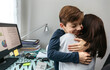 © David Pereiras - Mother and son hugging while she telecommutes