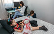 © David Pereiras - Children playing and doing homework while their mother works at home