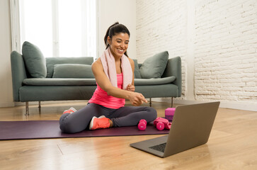 Wall Mural - Attractive woman on laptop in virtual online fitness class working out at home