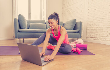 Wall Mural - Attractive woman on laptop in virtual online fitness class working out at home