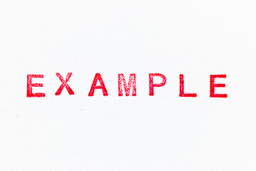 Red color example word ink rubber stamp on white paper background