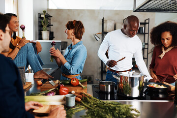 Diverse friends having fun cooking dinner