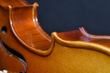 Sticker - Closeup shot of a wooden violin detail on a black background