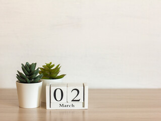 March 2 on a wooden calendar on a light background. Spring is in the yard.