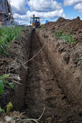 Wiring of an electric cable on the dug trench, supply of the electric power to the house on the earth.