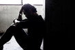 © Nutlegal - Smuggling illegal migrant worker was cuffed and detain Detainee young man sit in room get handcuff by bad person for using him to do hardworking He get depress Trafficked and smuggled persons concept