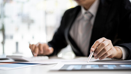 Businessmen are examining company financial information from documents prepared by the finance department.