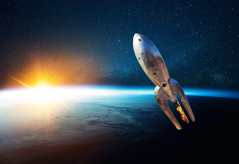 Fototapete - Metal vintage rocket with fire takes off into open starry space near the planet earth with sunset. Retro spacecraft lift off and flies on a background of the starry sky, planet and sunlight