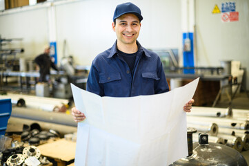 One engineers looking at a blueprint in a facility