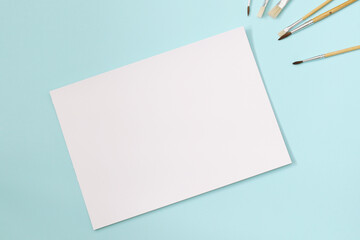 blank a4 paper sheet with paint brushes, mockup for arts