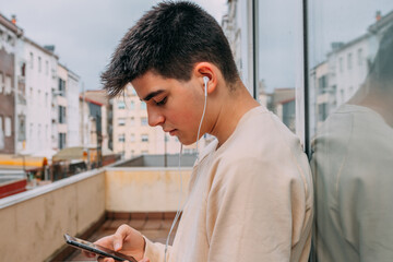 Wall Mural - young man with phone and headphones in the city