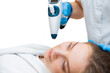 A beautiful girl is doing an anti-age cool lifting procedure with a non-injection gun on an isolated background