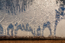 Frosty Patterns On A Window With A Wooden Frame . Frosting On A Frosty Winter Morning In Clear Weather. Close-up, Selective Focus.
