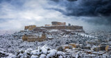 Panoramic view to the Parthenon Temple at the Acropolis of Athens, Greece, with skyline and old town with heavy snowfall in winter time