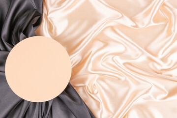 Wall Mural - Circle platform podium on elegant black and champagne color background with drapery and wavy folds of silk satin material. Pastel mock up background for cosmetic product presentation. Top view