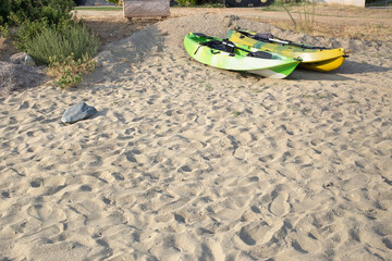 Empty sandy beach with footprints in the sand and two kayaks.Copy space,text space,holiday adventures.