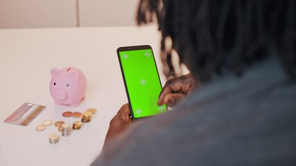  African american black man using mobile app for investing. Green screen on smartphone. High quality 4k footage