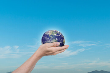 Canvas Print - globe, earth in human hands over blue sky background. idea for save the world. elements of this imag