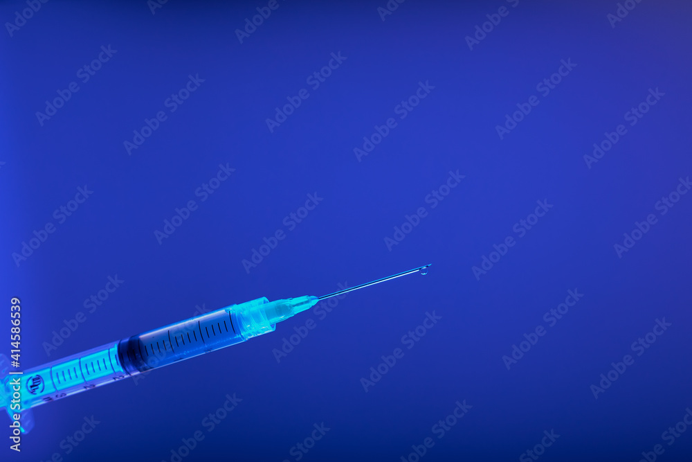 Jeringa hipodérmica para vacuna con fondo azul - obrazy, fototapety, plakaty 