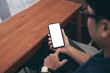 © panitan - cell phone blank white screen mockup.man hand holding texting using mobile on desk at office.background empty space for advertise.work people contact marketing business,technology