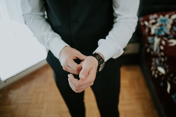 Closeup of a stylish and elegant man adjusting the beautiful and luxurious wristwatch on his hand