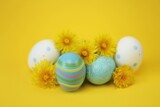 Fototapeta Mapy - Easter holiday.Blue striped and white Easter eggs, yellow dandelion flowers on a bright yellow background.Spring religious holiday background. 
