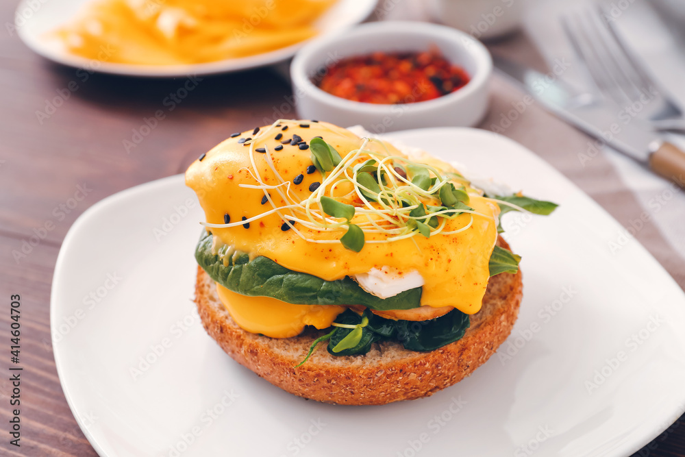 Tasty sandwich with florentine egg on wooden background, closeup