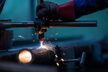 Wall Mural - Plasma cutting of the pipe. the operator cuts with a plasma torch