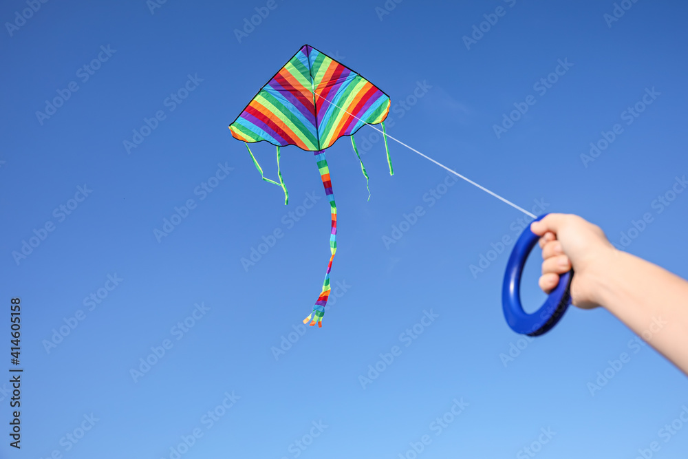 Girl flying kite in blue sky