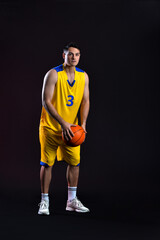 Male basketball player on dark background