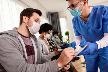 Wall Mural - Patient fills out the forms before receiving vaccine in clinic.