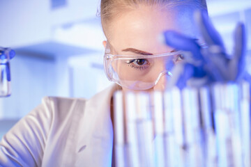 Laboratory concept background. Young scientist during experiment and using microscope in modern laboratory.