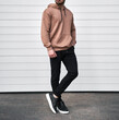 © AlexGo - Man is standing in brown hoodie and dark pants. Man is wearing light suede stylish long sleeve sweater.